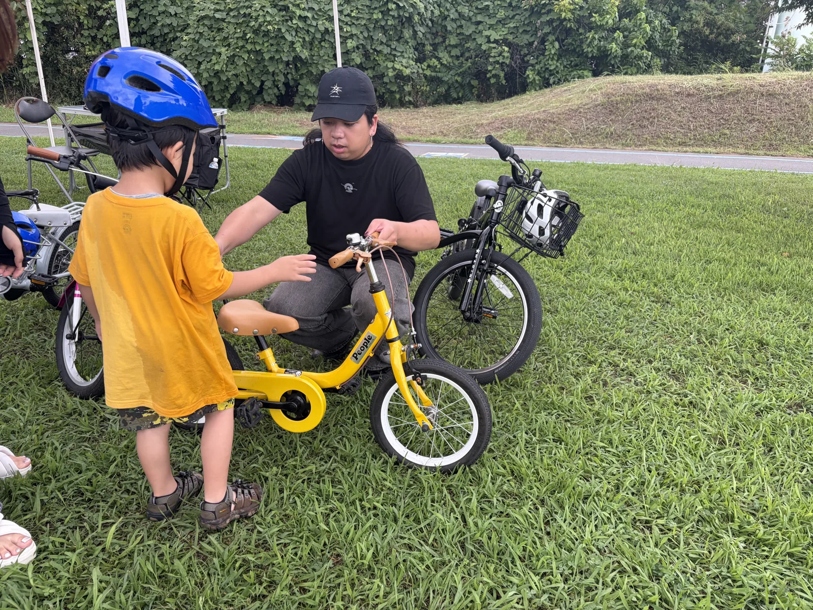こども用自転車のサイズを調整するスタッフ